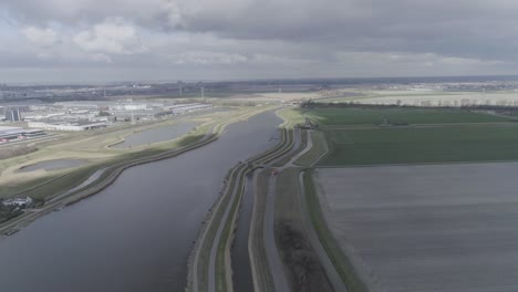 Drone-shot-of-big-river-between-Dutch-farmlands