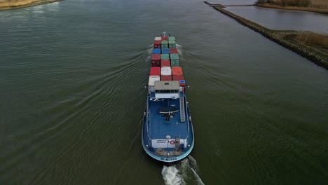 Aerial-view:-Container-ship-moving-through-the-canal-of-Zwijndrecht,-The-Netherlands