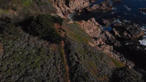 Hiking-footpath-fly-over-rocky-California-Coastline-in-Big-Sur