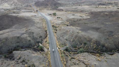Aerial-Overhead-View-Of-Vehicle-Driving-Along-RCD-Road-In-Balochistan