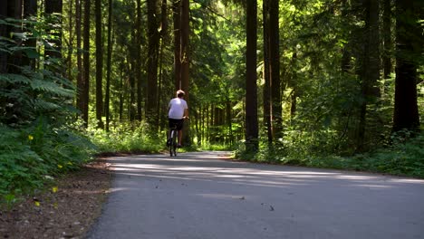 A-young-man-riding-a-bike-in-the-woods-on-a-sunny-day