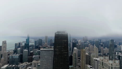 Aerial-view-low-clouds-moving-over-the-875-North-Michigan-Avenue,-in-gloomy-Chicago,-USA