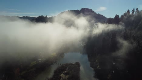 Luftaufnahme:-Flug-Durch-Niedrige-Wolken-über-Fluss-Und-Kleinstadt