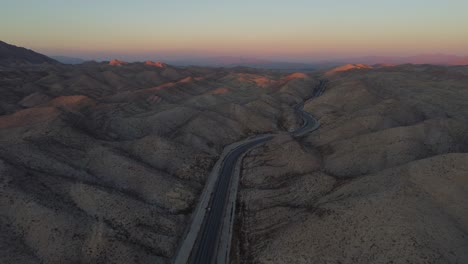 Aerial-View-Of-Sunset-On-Horizon-Over-RCD-Road-Through-Remote-Balochistan-Dramatic-Landscape