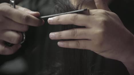 Closeup-Shot-Of-Barber-Combing-And-Cutting-Mens-Hair-At-A-Barbershop