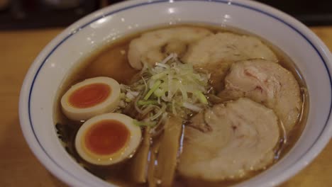 Close-pan-over-Japanese-Ramen-with-Pork,-Eggs-and-Vegetables