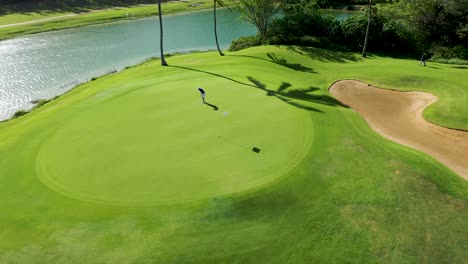 Golfer-on-putting-green-misses-the-shot-Aerial-shot-4K