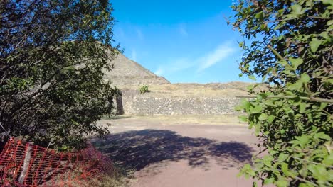 Teotihuacan-Pyramid-complex,-set-against-a-vivid-blue-sky,-and-a-captivating-shot-of-a-shrubland