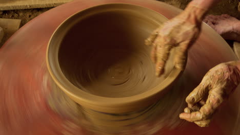 Free stock video - Close up top view of potter's hands with working with  wet clay on a pottery wheel making a clay product in a workshop