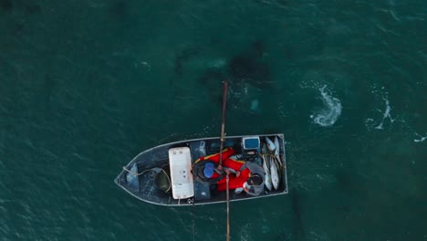 Birdseye-view-of-fishermen-rowing-back-to-shore-with-boat-full-of-fish-in-Bahia-Asuncion-Mexico