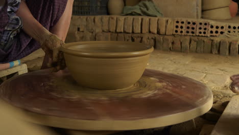 Free stock video - Close up top view of potter's hands with working with  wet clay on a pottery wheel making a clay product in a workshop