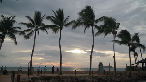 People-Enjoy-Majestic-Sunset-Over-Sea-at-Tanjung-Aru-Beach-Promenade---Slow-motion,-Establishing-Wide-shot