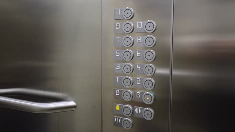 Female-hand-pressing-ground-floor-button-in-a-lift-elevator