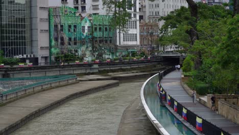 View-of-gently-river-stream-and-people-stroll-on-the-promenade-along-the-Klang-river-in-the-heart-of-Kuala-Lumpur-in-Malaysia