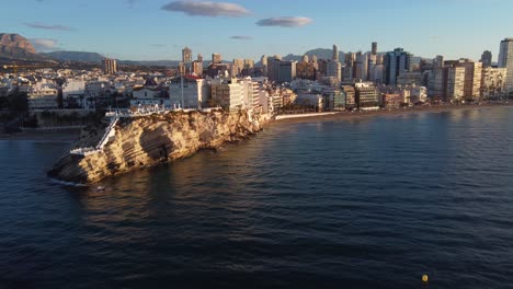 Aerial-dolly-in-towards-Benidorm-beachfront-buildings-at-sunset-time