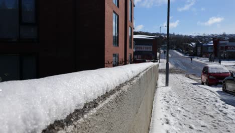 Eine-Schneebedeckte-Mauer-In-Einer-Stadtstraße-An-Einem-Sonnigen-Wintertag