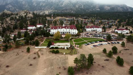 Aerial-view-pulls-away-from-Stanley-Hotel-in-Estes-Park-Colorado-on-cloudy-Fall-day