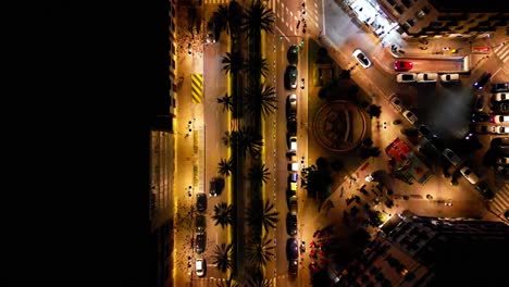 Nahaufnahme-Einer-Hauptstraße-Aus-Der-Vogelperspektive-Bei-Nacht-In-Der-Innenstadt-Von-Valencia,-Langsam-Bewegte-Aufnahme,-Mit-Menschen-Und-Autos