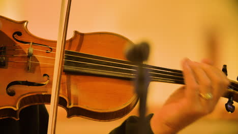 Close-up-of-male-violinist-playing-in-a-string-quartet-in-a-small,-bright-church