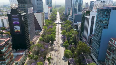 Aerial-view-March-8th-Women's-Day-march,-on-Paseo-de-la-Reforma-with-Jacarandas-trees,-Mexico-City,-8-march-2023