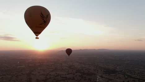 Close-up-drone-panning-shot-of-balloons-over-Bagan-in-Myanmar-during-Sunrise
