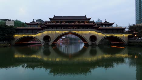 Anshun-Bridge-Illuminated-at-Night-in-Chengdu,-China-over-Jin-River---Aerial-Drone-Flight