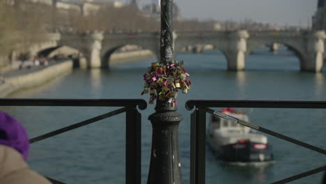 Tourists-walking-on-the-famous-bridge-ponts-des-arts-in-front-of-love-locks