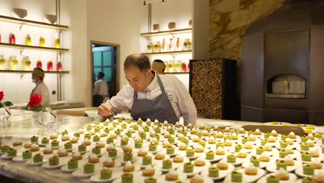 a-master-chef-adds-the-final-touches-to-hundreds-of-delicate-pastries---a-feast-for-the-senses