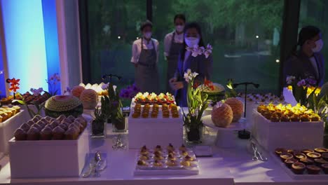 Hotel-staff-standing-behind-a-table-full-of-delicious-pastries-for-an-event