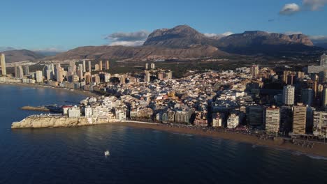 Benidorm,-Spain-with-Puig-Campana-mountain-in-the-background---aerial-establishing-shot