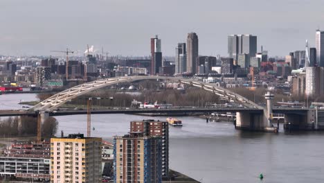 Aerial-panoramic-shot-of-cars-crossing-bridge-over-Nieuwe-Maas-in-Rotterdam-City,-Netherlands