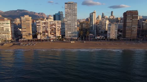 Sliding-aerial-view-of-the-hotels-and-resorts-on-the-beach-at-Benidorm,-Spain