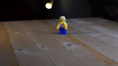 Teenage-plastic-toy-figure-on-a-wooden-table-with-dark-background