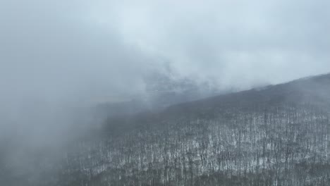 Drone-emerges-from-the-fog-over-top-of-cloud-covered-mountain