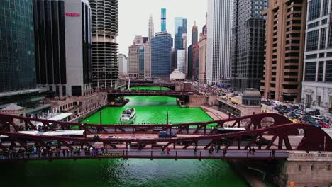 long-bus-on-bridge-and-boat-sailing-under-bridge-during-Saint-Patricks-day-in-chicago