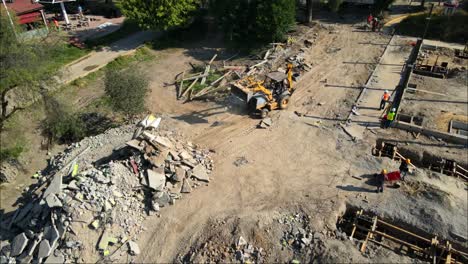 Vista-De-Drones-De-La-Excavadora-En-El-Sitio-De-Construcción-Del-Parque-De-La-Ciudad-Trabajando