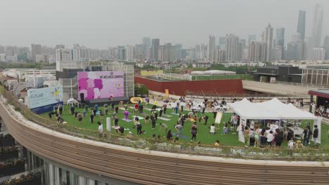 Women-doing-yoga-stretching-exercises-at-the-city-building-rooftop-fitness-festival