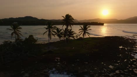 Luftaufnahme-Des-Goldenen-Sonnenuntergangs-Mit-Tropischen-Palmen-Am-Strand-Von-El-Cayito,-Dominikanische-Republik