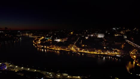 Nächtliche-Drohnenaufnahmen-Des-Flusses-Douro-Im-Herzen-Von-Porto,-Portugal