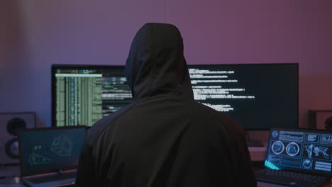 Die-Polizei-Kommt,-Um-Einen-Anonymen-Hacker-Mit-Braunem-Kapuzenpulli-Vor-Bildschirmen-Zu-Erwischen