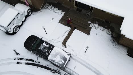 High-angel-pan-with-drone-of-a-man-shoveling-snow