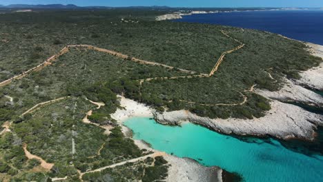 Es-talaier-virgin-white-sand-beach-in-Menorca-Spain-seen-from-above-with-rugged-track-leading-to-the-location