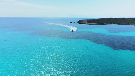 Filmische-Luftaufnahmen-Eines-Vorbeifahrenden-Luxus-Schnellboots-An-Einem-Perfekten-Sommertag-Auf-Menorca,-Spanien