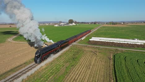 Drone-View-of-a-Steam-Passenger-Train-Blowing-Lots-of-Smoke-and-Steam-Starting-Up-on-a-Sunny-Fall-Day
