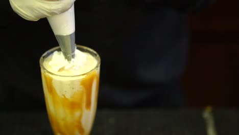 Fresh-Cream-Being-Applied-To-Milkshake-With-Caramel