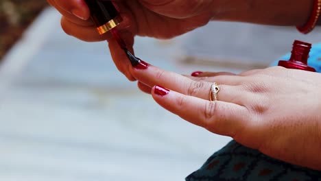 young-girl-doing-nail-polish-on-nails-at-day-in-details