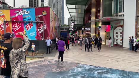 Crowds-wait-and-stroll-outside-Lot-10-Mall-in-Bukit-Bintang,-Kuala-Lumpur,-Malaysia