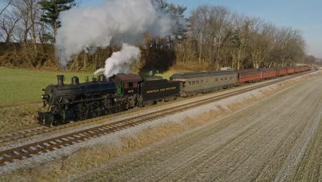 A-Drone-View,-in-Slow-Motion,-of-a-Antique-Steam-Passenger-Train,-Traveling-Thru-Farmlands-on-a-Winters-Day