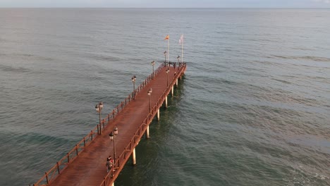 Wooden-jetty-on-the-Mediterranean-sea-with-people-walking-on-it