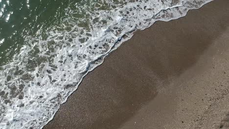 Aerial-views-over-beaches-with-calm-and-relaxing-waves-along-the-shore